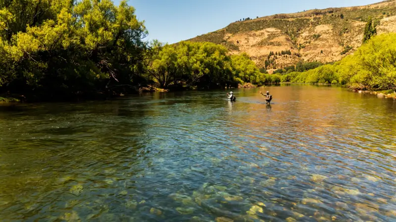 Two anglers wet wading a clear emerald river in high summer, Argentine Patagonia