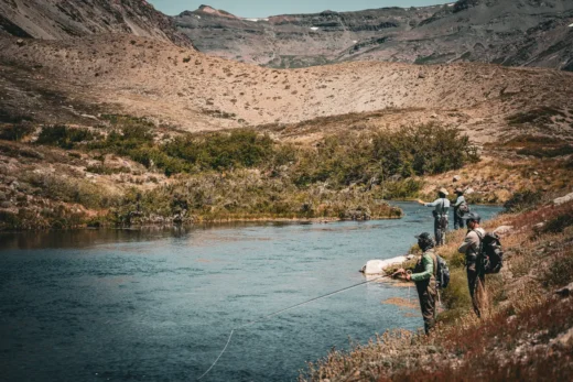 Anglers walking the bank of a wide freestone river in northern Patagonia