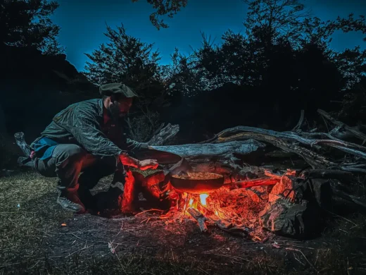 Cooking over the campfire at dusk in a fly fishing camp