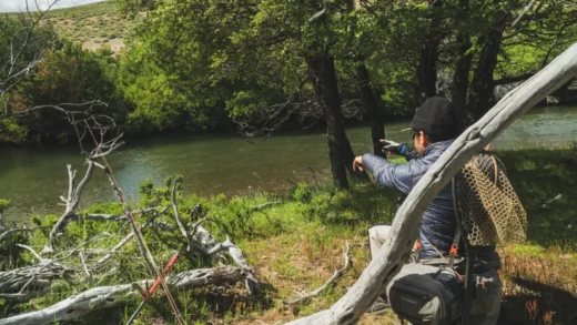 Tree lined river bend with an angler working the far bank