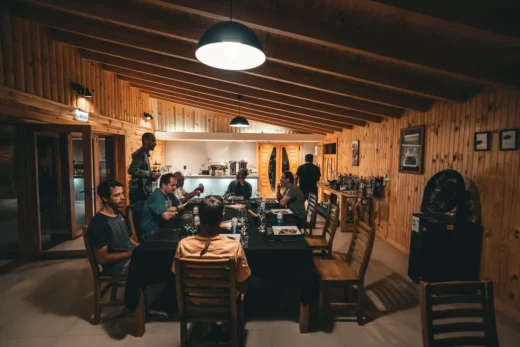 Guests sharing dinner in the timber dining room of the lodge