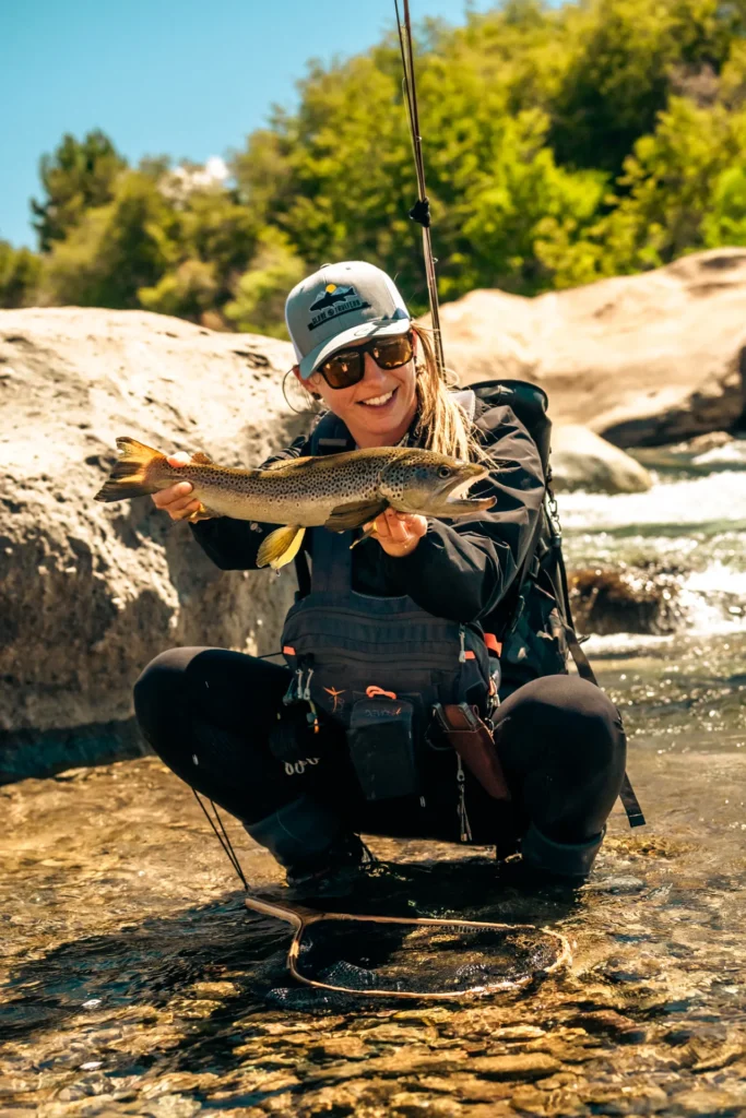 Smiling angler holding a large brown trout in Patagonia, Argentina