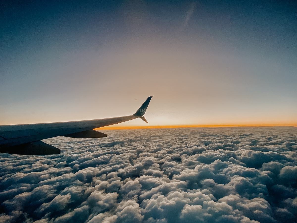 Airplane wing above a sea of clouds at sunrise on the overnight flight to Buenos Aires